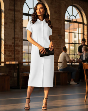 Woman in a white dress standing in a restaurant with large windows.