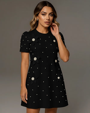 Woman wearing a black dress with white polka dots against a gray background