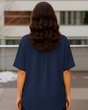 Person wearing a navy blue shirt with a blurred background