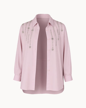 Pink blouse with embellishments on a white background