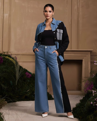 Woman wearing a denim jacket and black pants with white shoes in an outdoor setting.