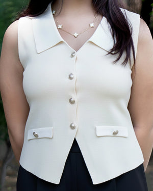 White sleeveless blazer worn by a person with a blurred background