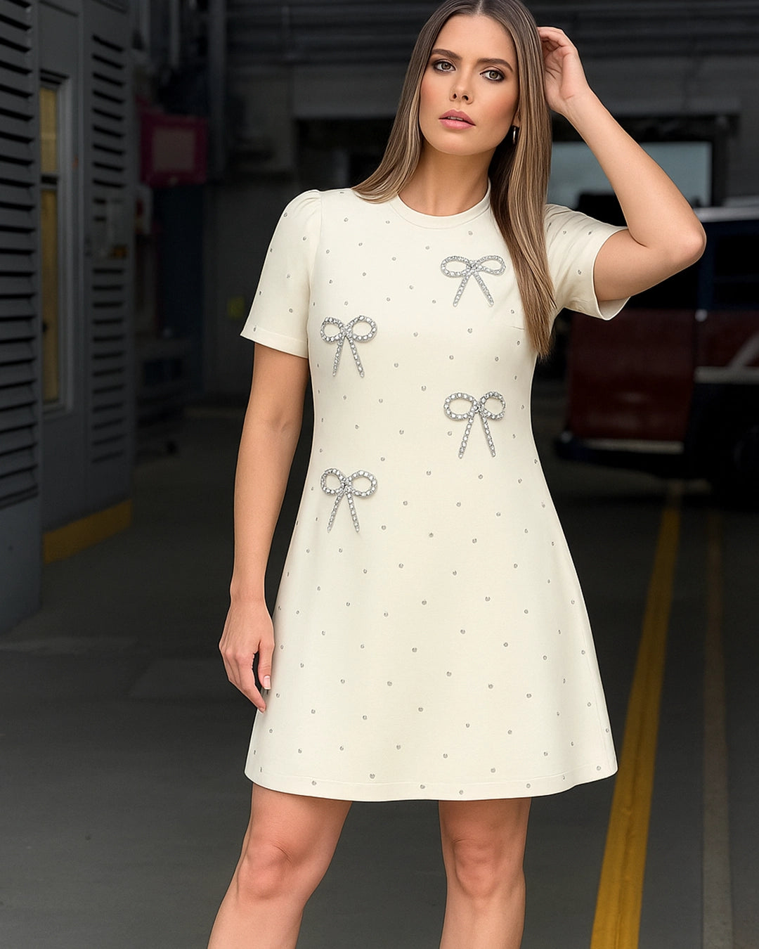 Woman wearing a white dress with decorative bows in an industrial setting