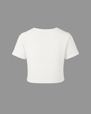 White ribbed knit crop top on a gray background