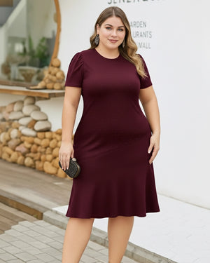 Woman wearing a burgundy dress standing outdoors with a blurred background
