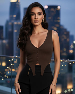 Woman in a brown sleeveless top with cut-out design against a city skyline at night.