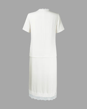 White dress with lace hem on a gray background