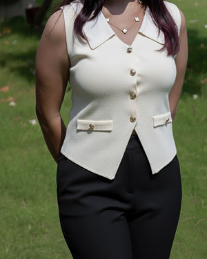 Person wearing a white vest with gold buttons against a grassy background