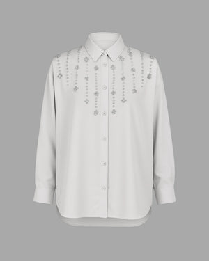 White shirt with floral embroidery on a gray background