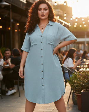 Woman wearing a light blue dress standing outdoors with people and tables in the background