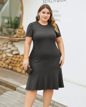 Woman wearing a black dress standing outdoors with a blurred background