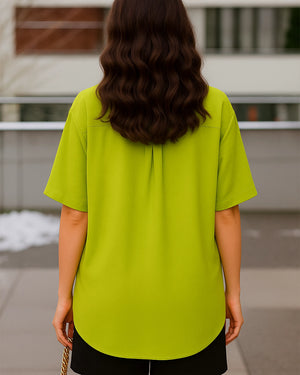 Person wearing a bright green shirt with a blurred background