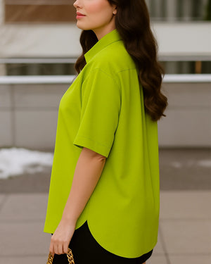 Woman wearing a bright green shirt with a blurred background