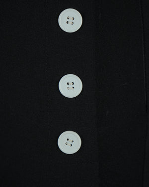 Close-up of a black coat with three white buttons.