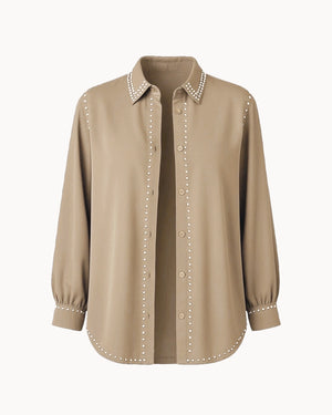 Beige shirt with pearl embellishments on a white background