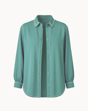 Teal shirt with decorative trim on a white background