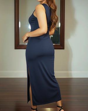 Woman wearing a navy blue dress with a side slit, standing in front of a mirror.