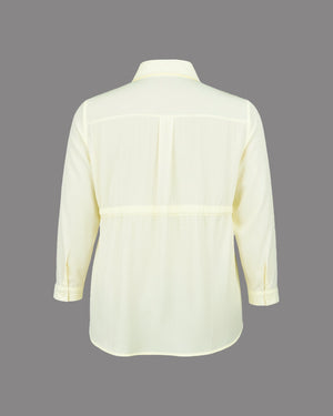 Light yellow shirt on a gray background