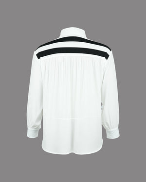 White shirt with black accents on a gray background