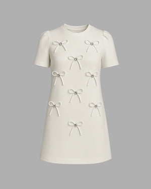 White dress with bow details on a gray background