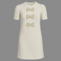 White dress with bow details on a gray background