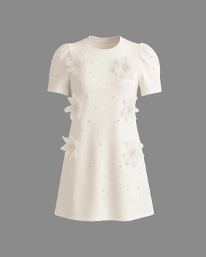 White dress with floral embellishments on a gray background