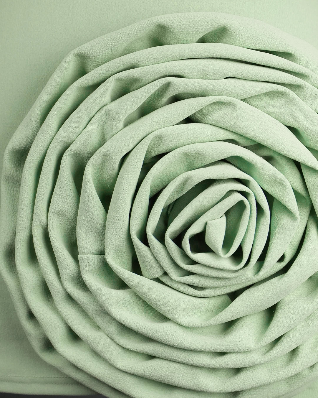 Rolled-up light green fabric on a matching background