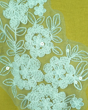Close-up of floral lace fabric with a green background