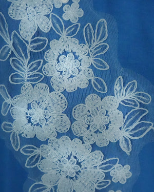 White floral lace on a blue fabric background