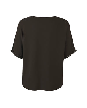Black blouse with decorative trim on sleeves against a white background