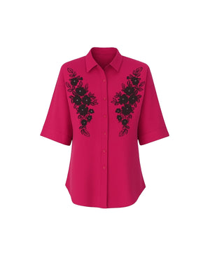 Pink shirt with black floral embroidery on a white background