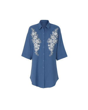 Blue shirt with floral embroidery on a white background