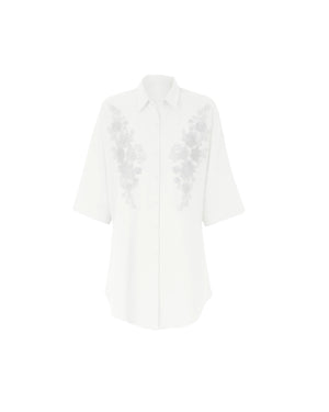 White blouse with floral lace details on a white background