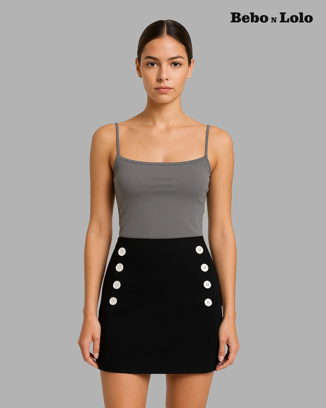 Woman wearing a gray top and black skirt with button details on a gray background, featuring the brand 'Bebó n Lolo'.