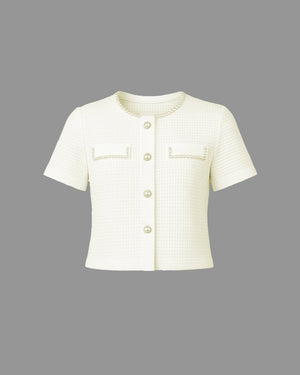 Short-sleeve cream-colored jacket with button details on a gray background