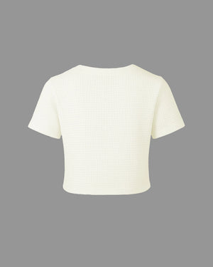White ribbed knit crop top on a gray background