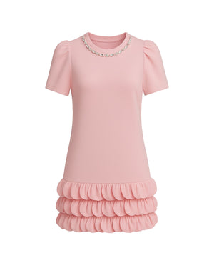 Pink dress with ruffled skirt on a white background