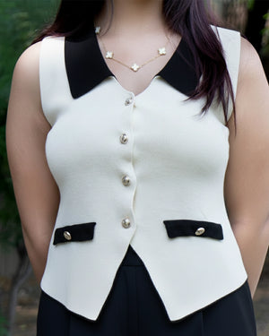 White vest with black collar and buttons worn by a person outdoors