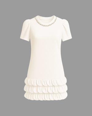 White dress with ruffled skirt and pearl neckline on a gray background