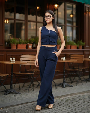 Woman in a navy blue outfit standing in an outdoor cafe setting