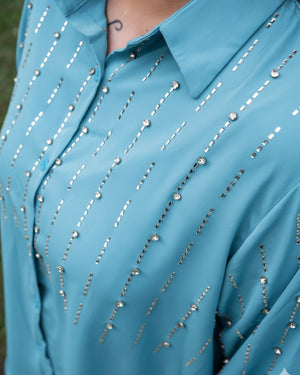 Close-up of a blue shirt with silver bead embellishments.