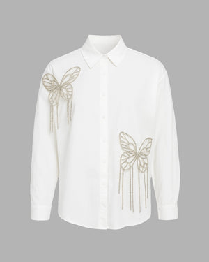 White shirt with butterfly designs on a gray background