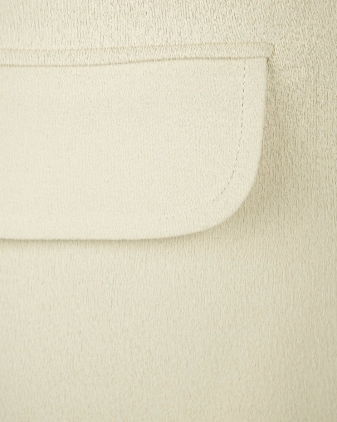 Close-up of a beige fabric with a pocket detail