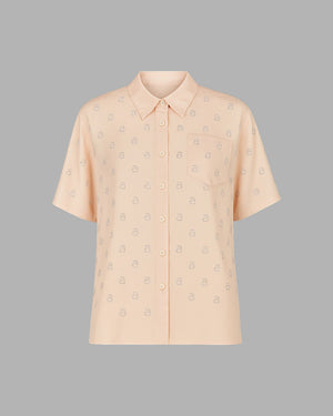 Beige short-sleeve shirt with subtle pattern on a gray background