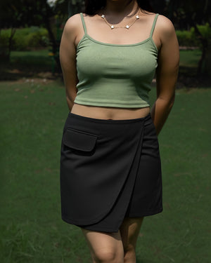 Person wearing a green top and black skirt outdoors