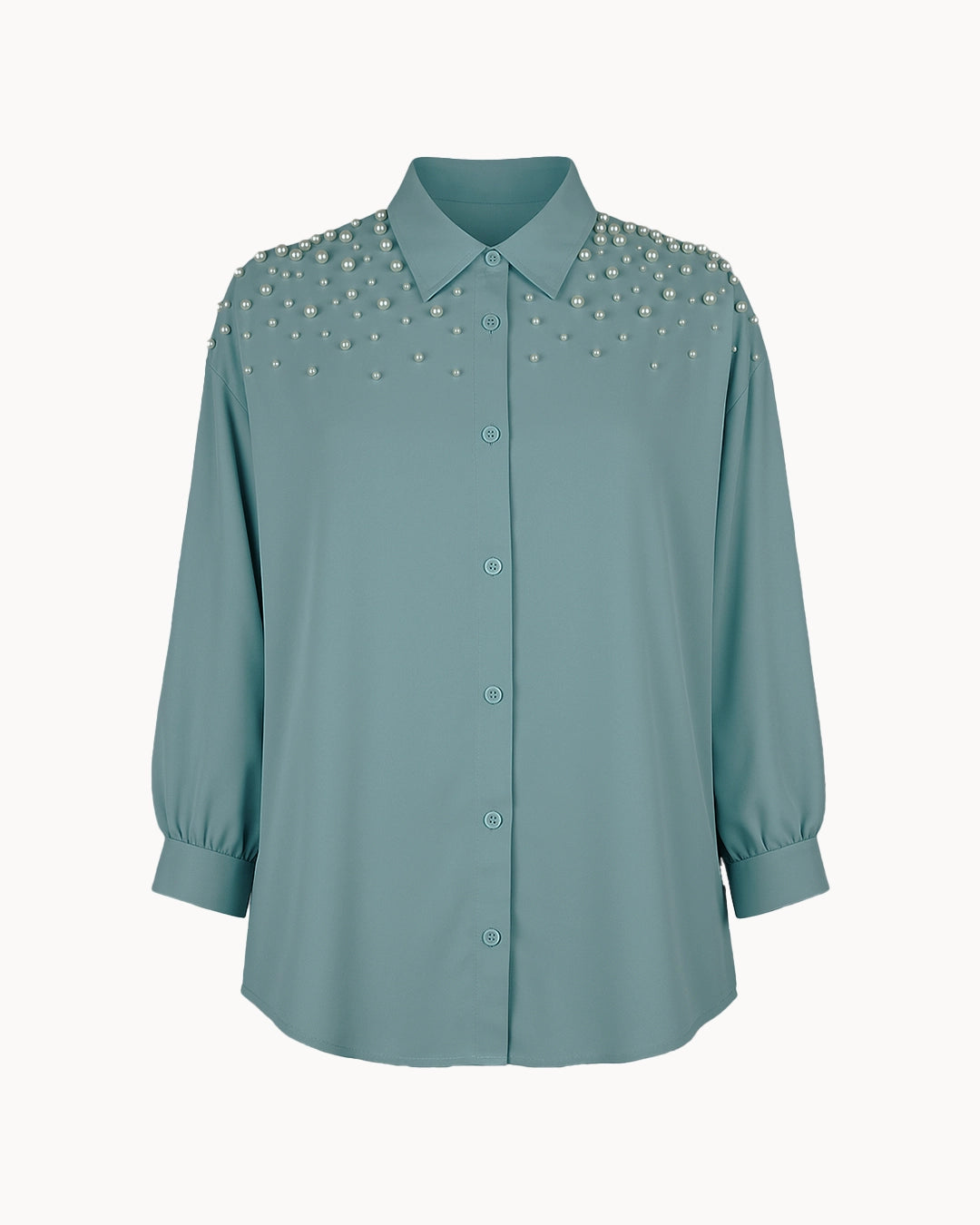 Teal shirt with decorative embellishments on a white background