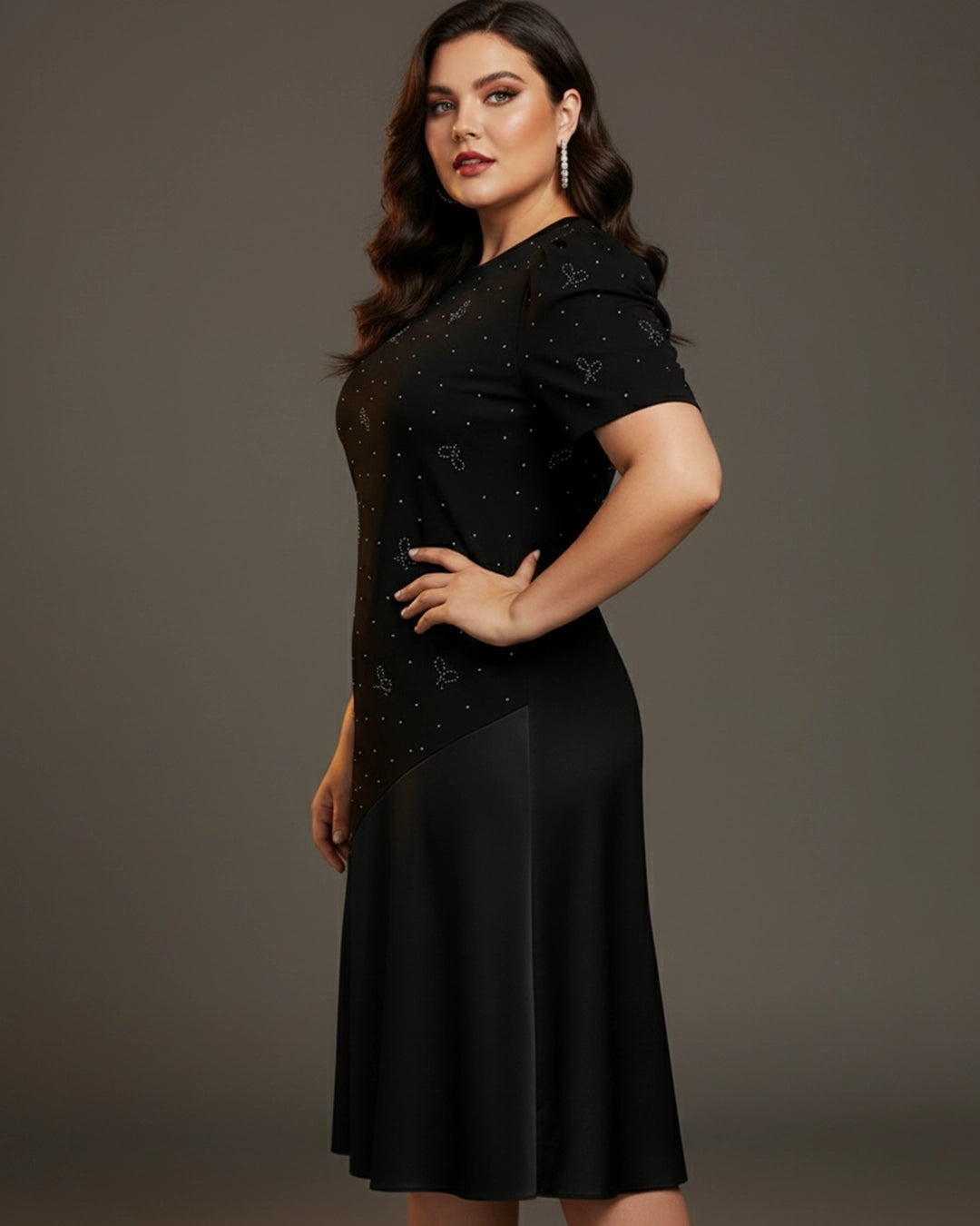 Woman wearing a black dress with a star pattern on a gray background