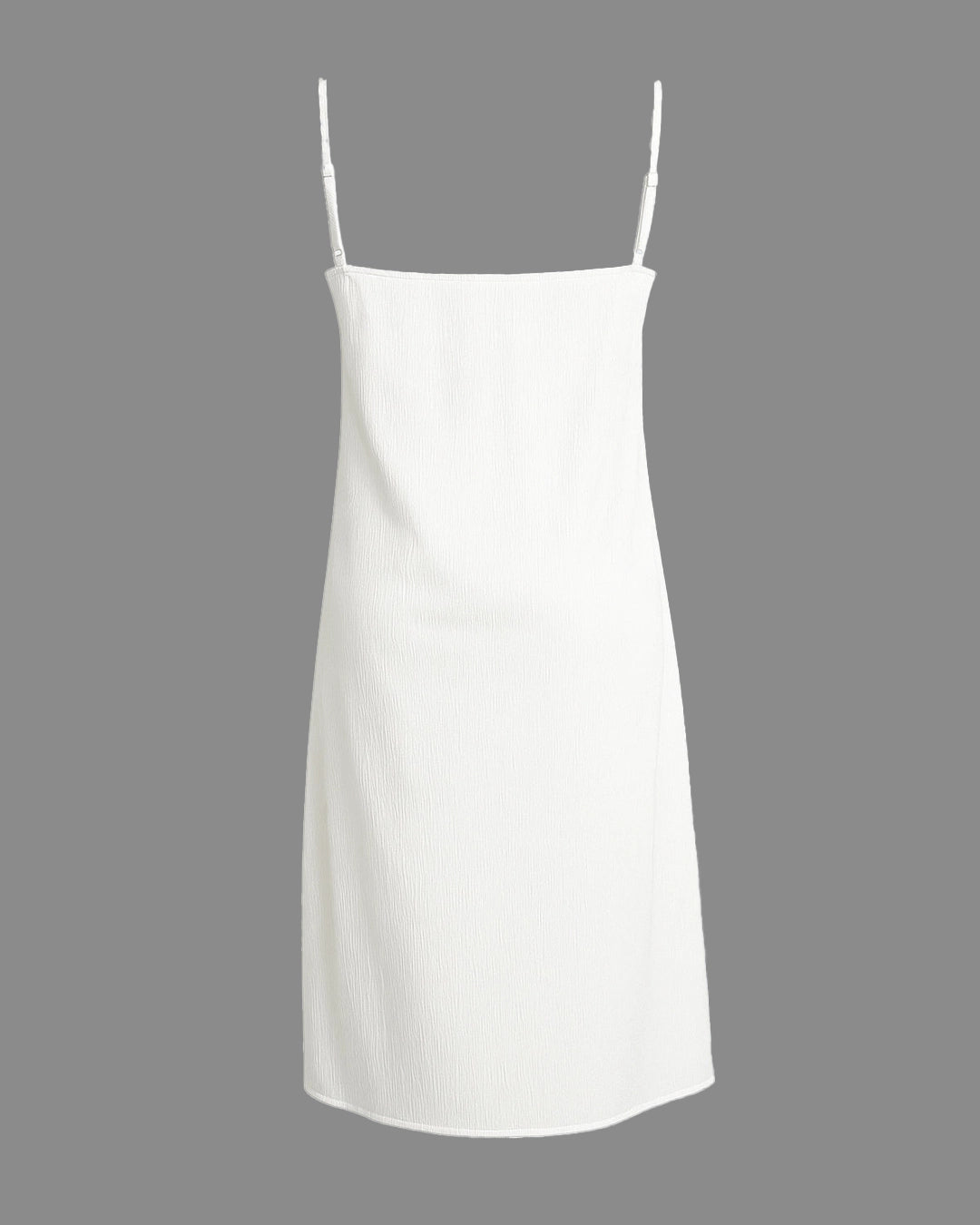 White slip dress with thin straps on a gray background