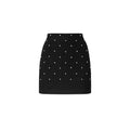 Black mini skirt with white polka dots on a white background