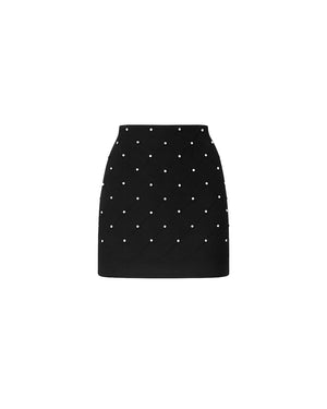Black mini skirt with white polka dots on a white background